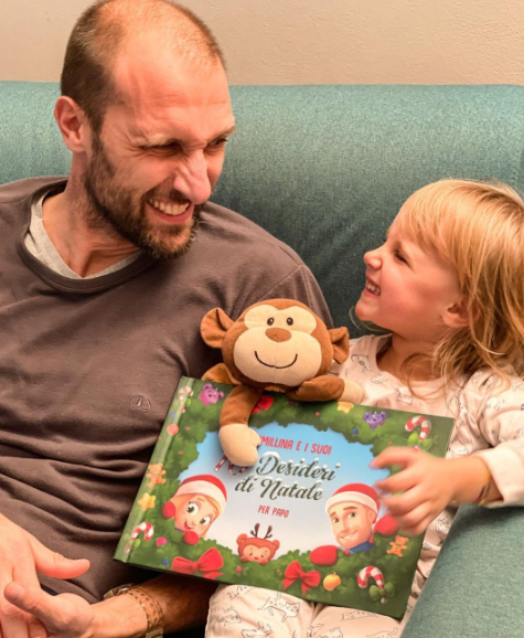 A daddy and his 4 year-old daughter and her Christmas gift idea from Hooray Heroes: a personalized book for kids.